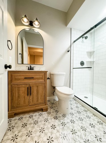 A bathroom with a toilet, sink, and mirror.