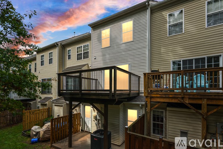 A balcony with a table and chairs is attached to a house.