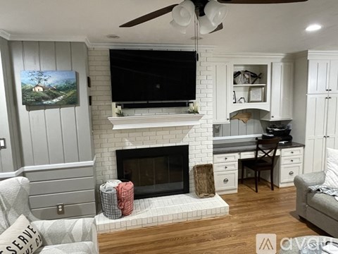 A living room with a fireplace and a television above it.