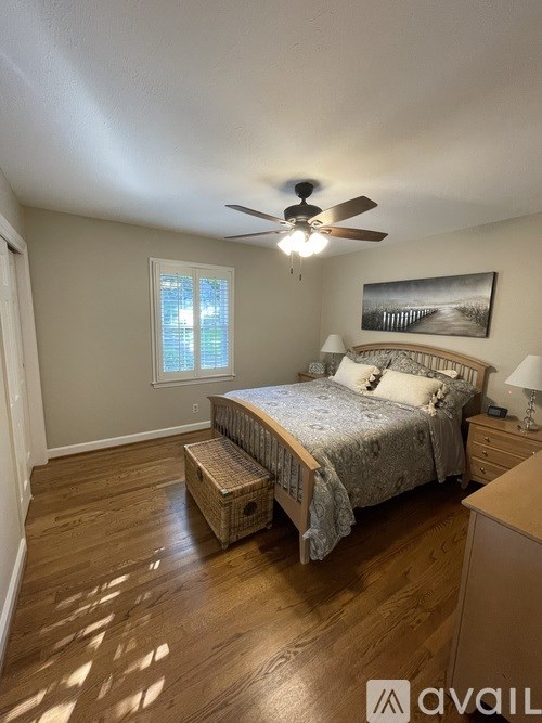 A bedroom with a bed, dresser, and window.