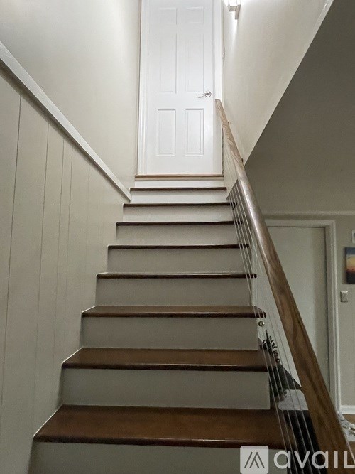 A staircase with wooden steps and white walls.