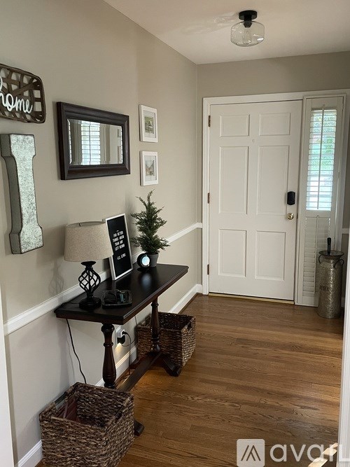 A hallway with a table and a lamp on it.