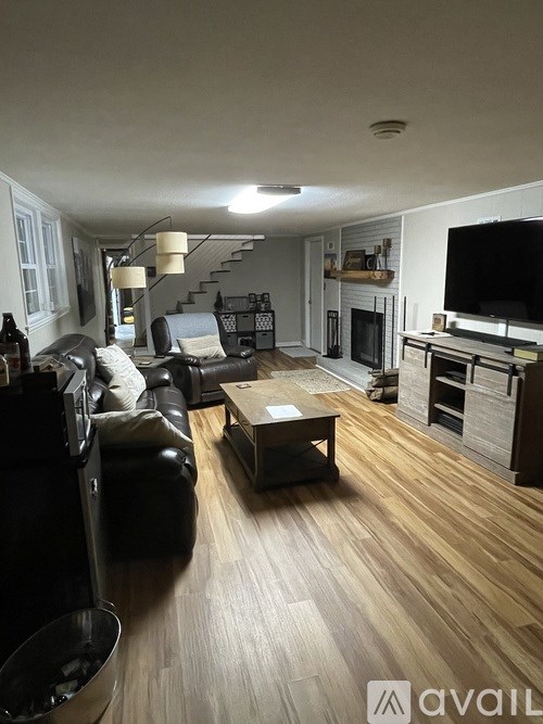 A living room with a black leather couch and a wooden coffee table.