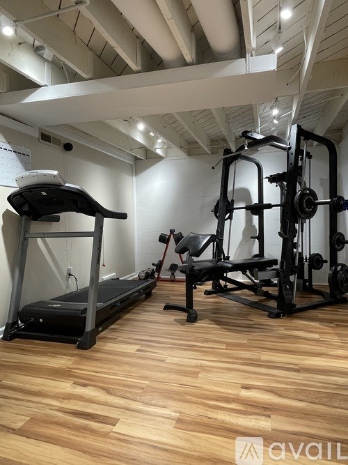 A gym with a treadmill and a weight machine.