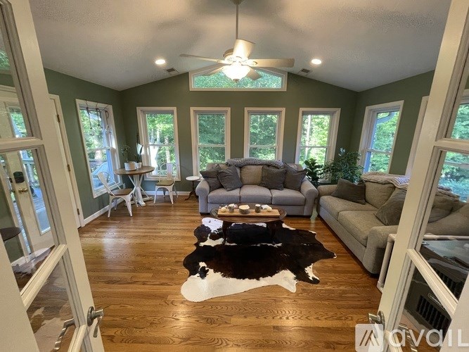 A living room with a cowhide rug in the center.