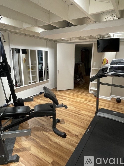 A gym with a treadmill and a weight machine.
