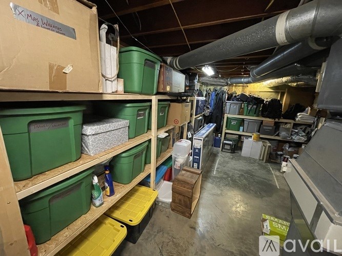 A storage room with green bins and containers on shelves.