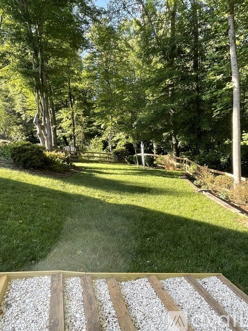 A garden with a wooden bench and a gravel path.