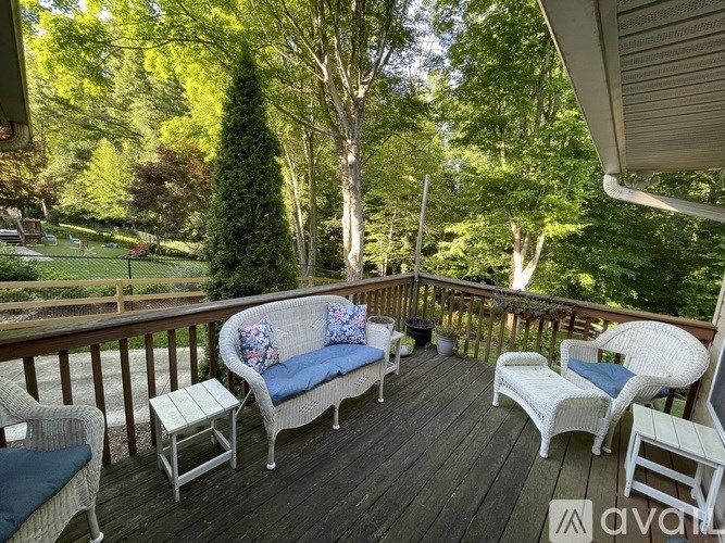 A wooden deck with a sofa, chairs and a table.