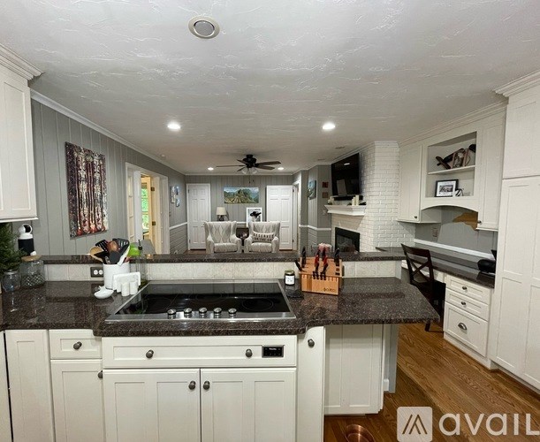 A kitchen with a black granite countertop and white cabinets.