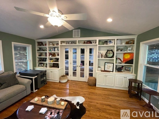 A living room with a couch, coffee table, and a ceiling fan.