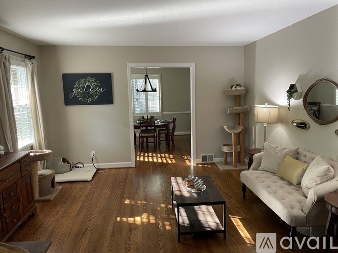 A living room with a couch, coffee table, and a mirror on the wall.