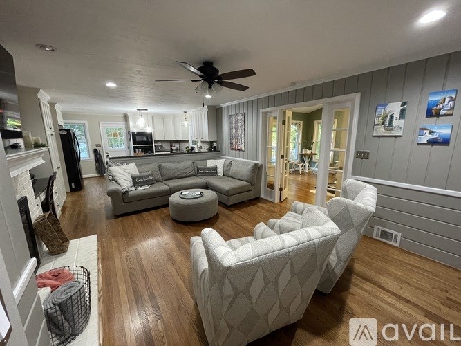 A living room with a grey couch and a white chair.