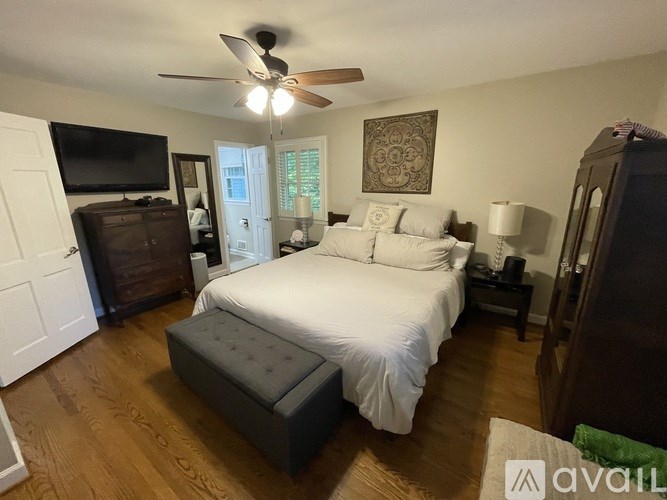 A bedroom with a large bed and a ceiling fan.