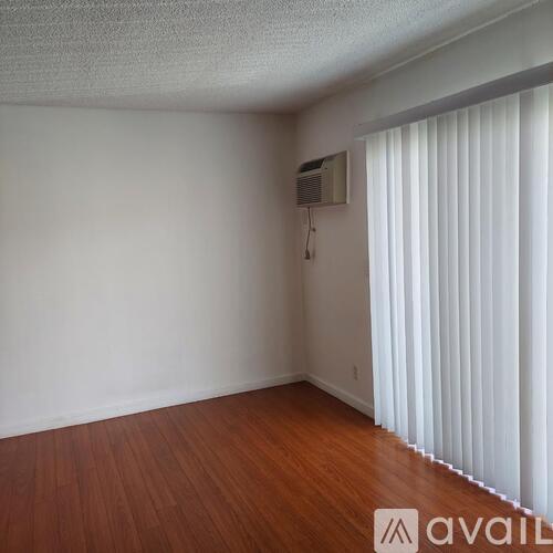 A hallway with a wooden floor and white walls.