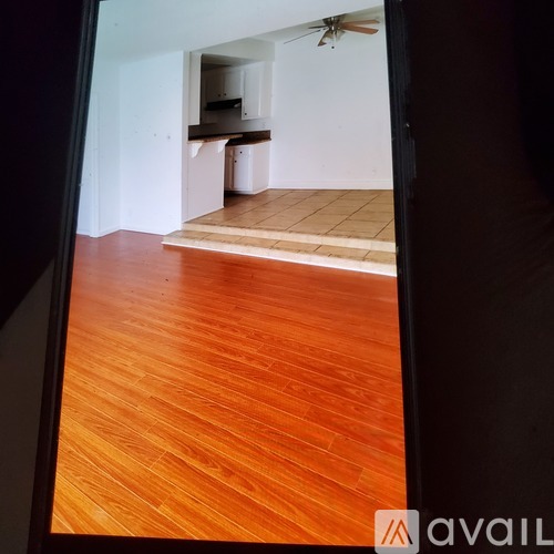 A room with wooden flooring and a fan on the ceiling.