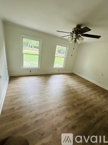 A room with wooden floors and a ceiling fan.