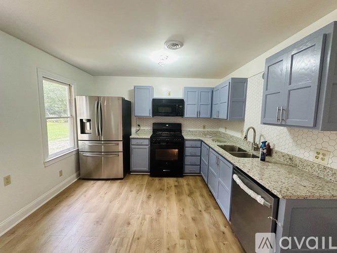 A kitchen with wooden floors and a stainless steel refrigerator.