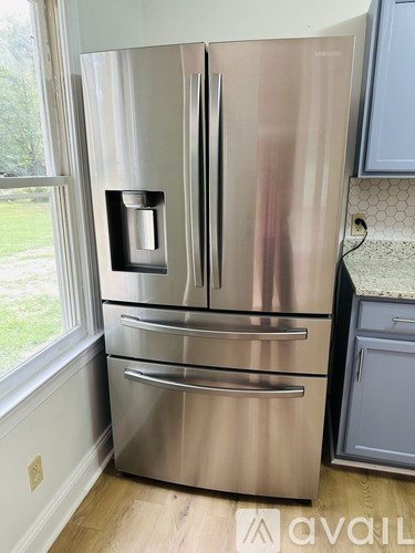 A stainless steel Samsung refrigerator with a water and ice dispenser in the door.