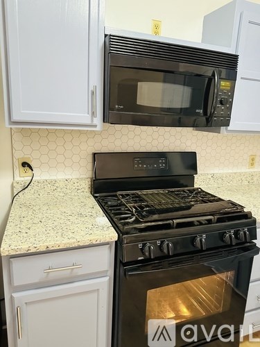 A black stove top oven with a glass door sits on a kitchen counter.
