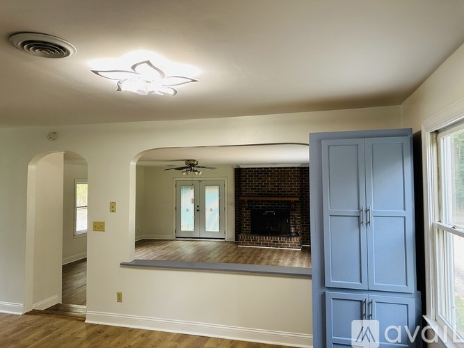 A living room with a fireplace and a ceiling fan.