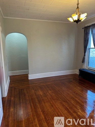 A room with wooden floors and a chandelier.