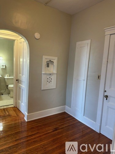 A room with a wooden floor and white doors.