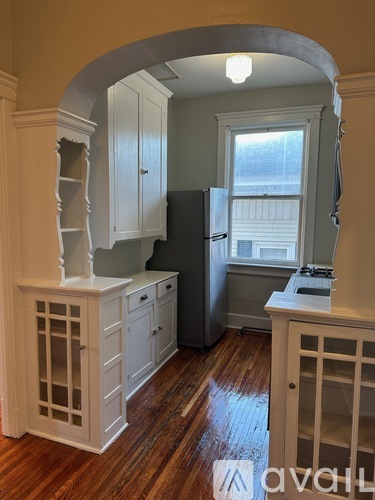 A kitchen with wooden floors and white cabinets.