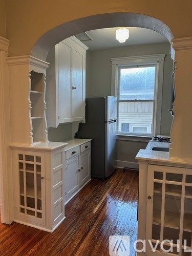 A kitchen with wooden floors and white cabinets.
