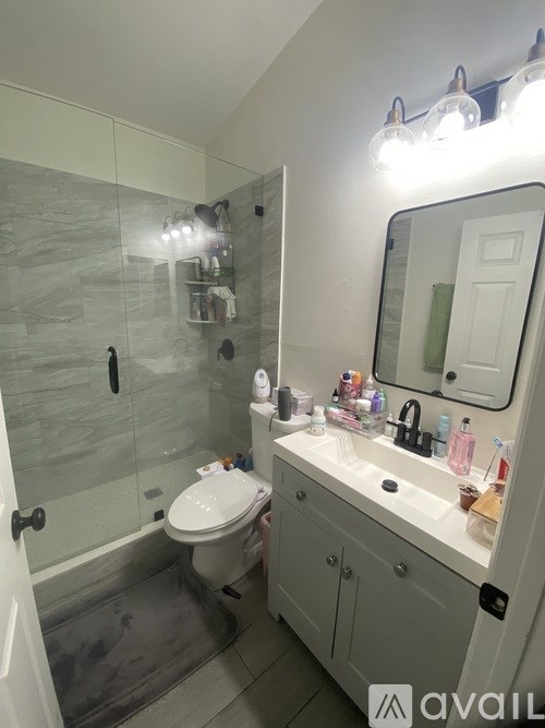 A bathroom with a toilet, sink, and mirror.