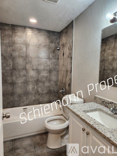 A bathroom with a toilet, sink, and tiled walls.