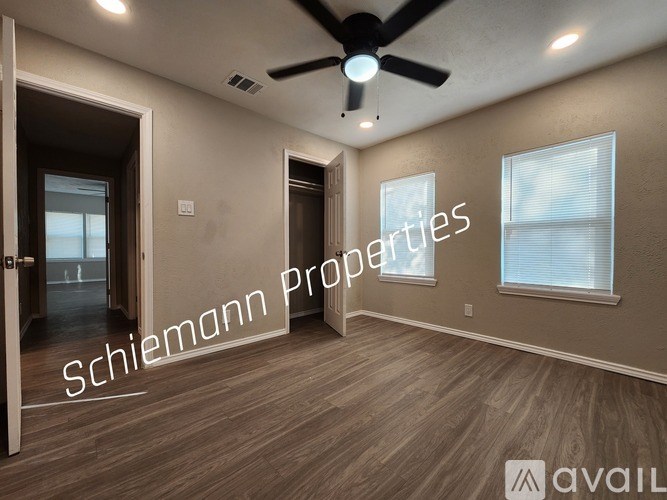 A room with a ceiling fan and a window with blinds.