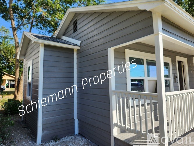 A Schiemann Properties house with a grey exterior and a white porch.