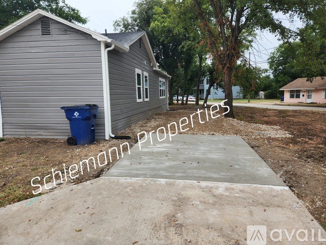 A house with a sign that says "Schlemann Properties" in front of it.