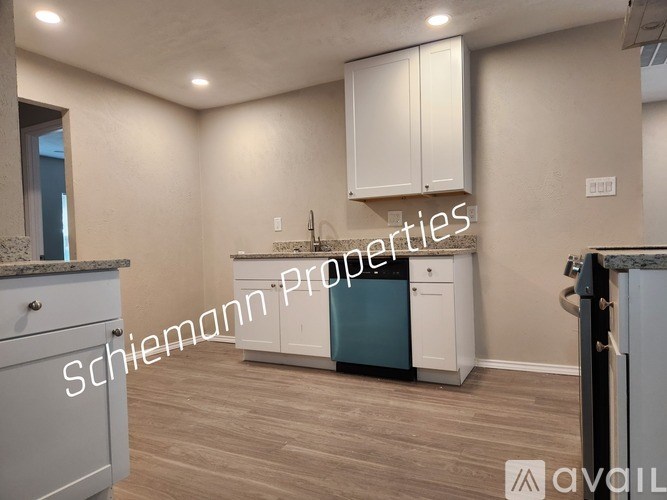 A kitchen with a countertop, cabinets, and a dishwasher.