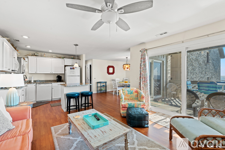 A living room with a couch, a coffee table, and a ceiling fan.