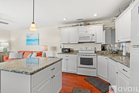 A kitchen with white cabinets and a granite countertop.
