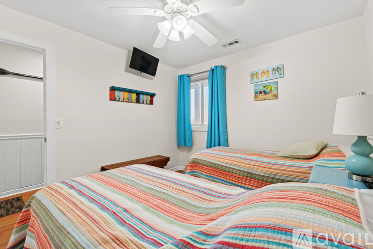 A bedroom with two beds and a ceiling fan.
