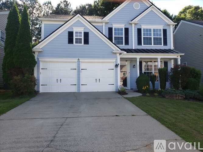 A two-story house with a garage and a driveway.