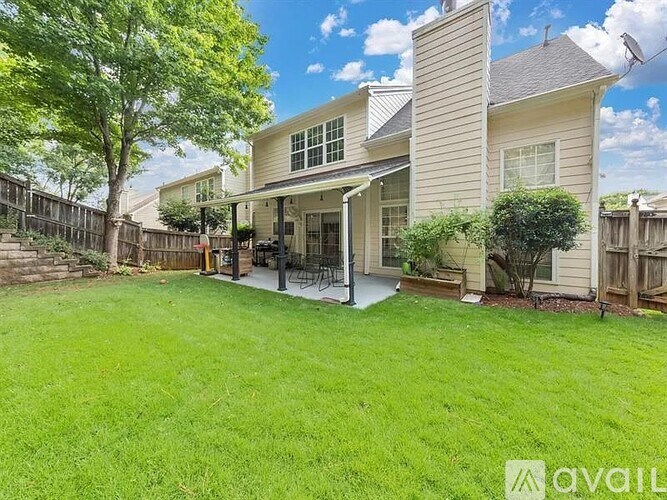 A house with a well-maintained lawn and a fence in the background.
