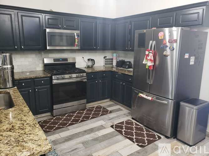 A kitchen with black cabinets and granite countertops.