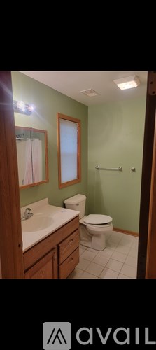 A bathroom with green walls and a white toilet.