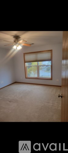 A room with a ceiling fan and a window.