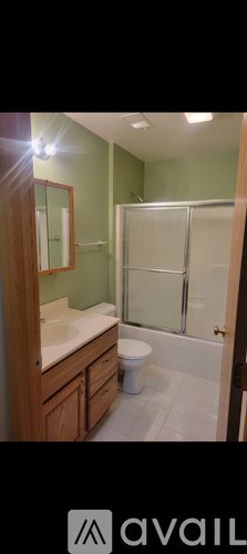 A bathroom with green walls and a white toilet.