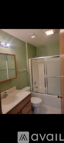 A bathroom with green walls, a white sink, and a toilet.