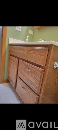 A wooden cabinet with a white countertop and a single drawer is shown.