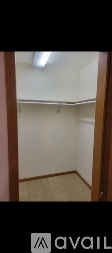 A small, empty room with a white wall and a wooden door.