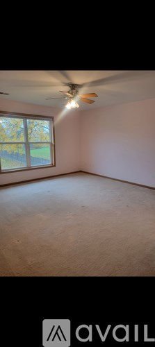 A room with a ceiling fan and a window.