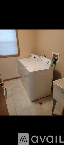 A white washing machine in a room with beige walls.