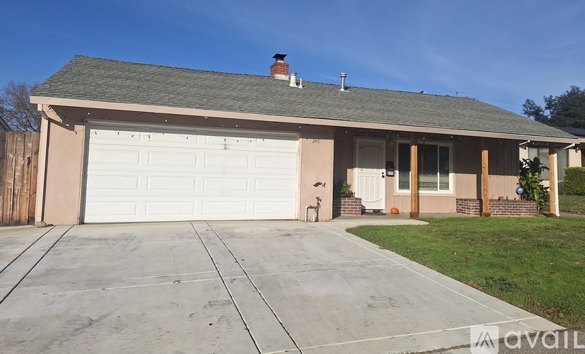 A house with a white garage door and a brown roof.